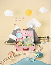 Paper diorama of mountains and a cable car around a pink suitcase