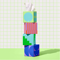 A stack of patterned tissue boxes on a grid backdrop