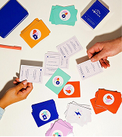 Hands sorting illustrated cards on a white table